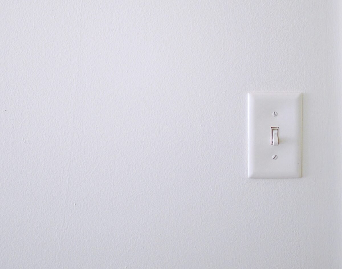 Smart learning thermostat mounted on wall displaying current temperature *Caption: Smart thermostats learn your schedule and can reduce heating costs by 10-15%*