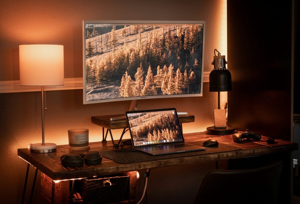 LED bias lighting strips behind television glowing with warm orange and purple colors that match the on-screen scene
