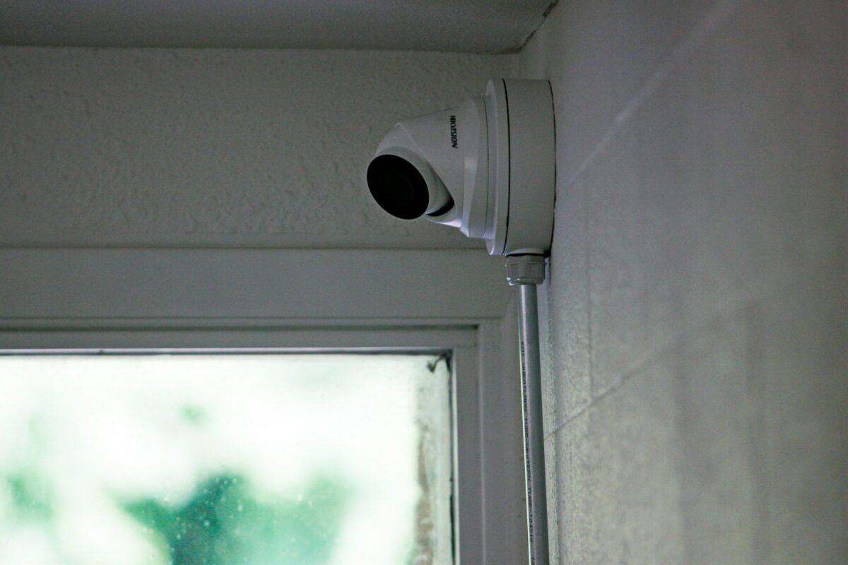 Outdoor security camera mounted under house eaves with night vision activated 