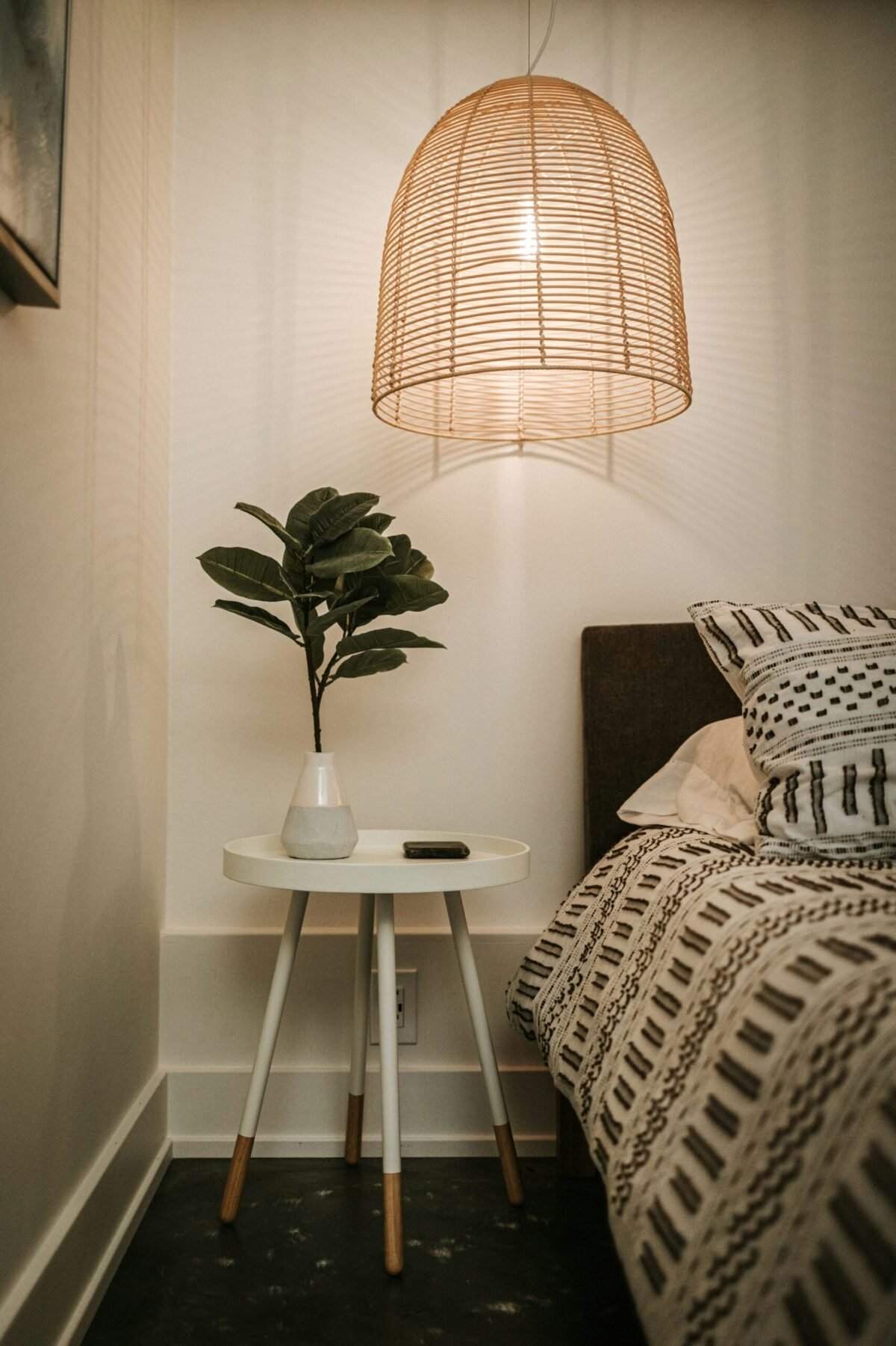 Minimalist nightstand with a smart lamp, fabric-covered smart speaker, and discreet smart button blending seamlessly with bedroom decor