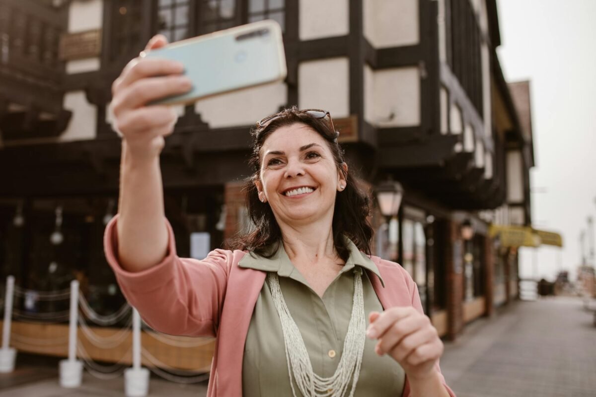 Person walking out of modern front door holding smartphone, smart lock visible on door frame with keypad