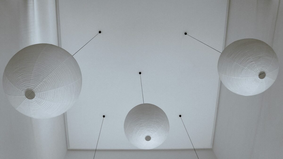 White in-ceiling speaker mounted flush with ceiling surface, painted to match surrounding ceiling color