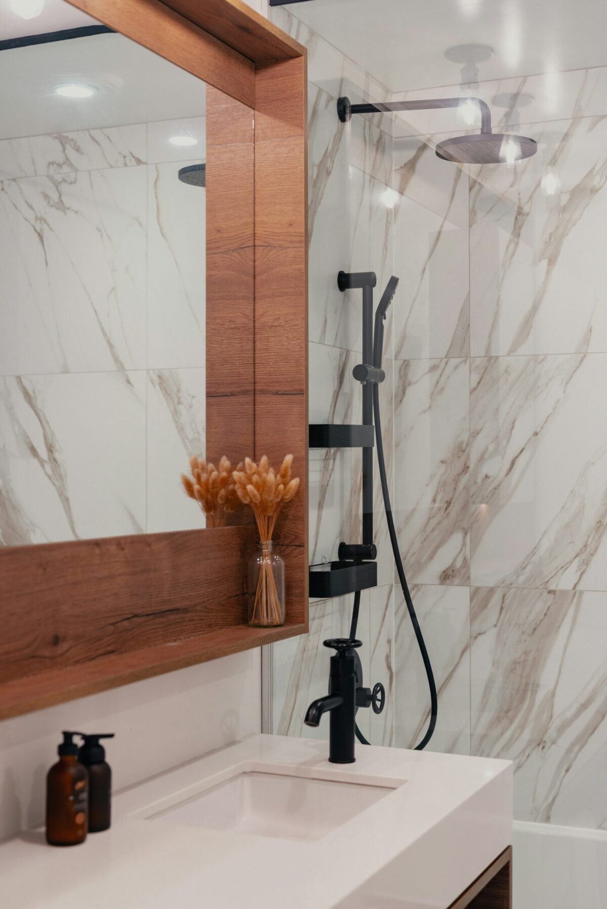 Close-up of a digital smart shower control panel with temperature display and preset buttons on a tiled wall.