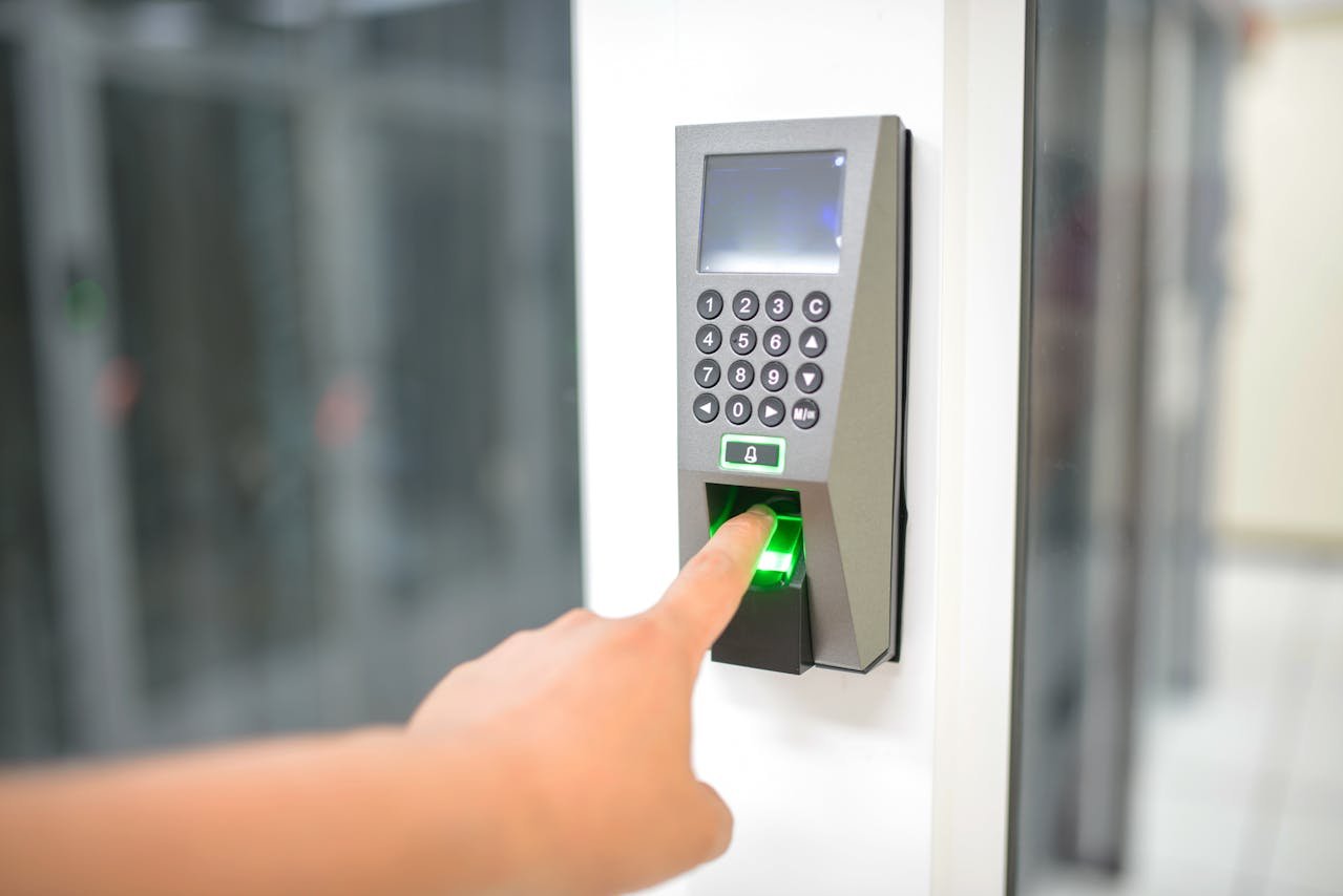 Close-up of hand entering code on backlit keypad of modern smart lock on front door